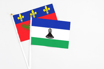 Lesotho and Guadeloupe stick flags on white background. High quality fabric, miniature national...