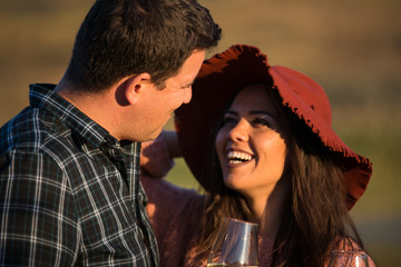 Happy romantic couple laughing and enjoying a glass of wine