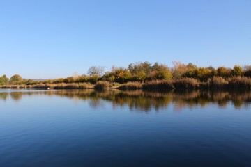 Fototapeta na wymiar Lake shoreline reflecting symmetric in the water