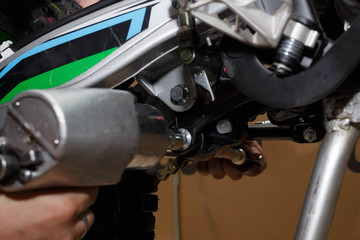 Master installs on a motorcycle or replaces the rear shock absorbers.