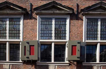 Fototapeta na wymiar Close up view of historical, traditional windows and shutters showing Dutch architectural style in Amsterdam. It is a sunny summer day.
