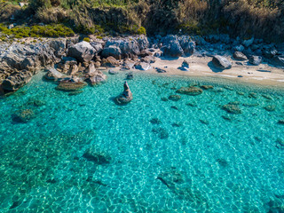 Aerial view of Tropea beach, crystal clear water and rocks that appear on the beach. Calabria, Italy. Swimmers, bathers floating on the water. Coastline of Calabria