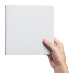Obraz premium Hand holding a blank hard cover square book, isolated on white background