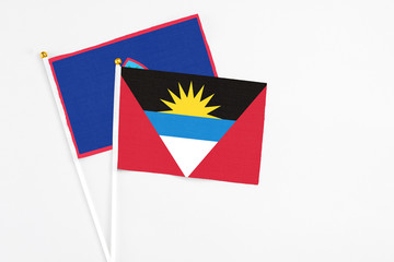 Antigua and Barbuda and Guam stick flags on white background. High quality fabric, miniature national flag. Peaceful global concept.White floor for copy space.
