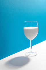 Glass of milk in blue and white background