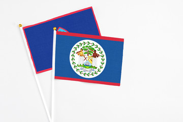 Belize and Guam stick flags on white background. High quality fabric, miniature national flag. Peaceful global concept.White floor for copy space.