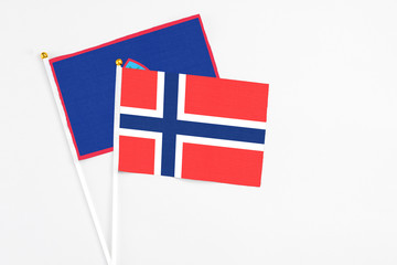 Obraz premium Bouvet Islands and Guam stick flags on white background. High quality fabric, miniature national flag. Peaceful global concept.White floor for copy space.