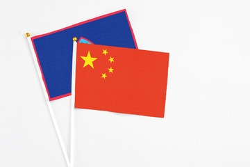 China and Guam stick flags on white background. High quality fabric, miniature national flag. Peaceful global concept.White floor for copy space.