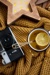 flat lay cozy autumn photo for a blogger with a warm sweater and tea with lemon and cinnamon, a...