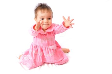 Funny surprised little girl in pink dress plays with soap bubbles on white isolated background. Happy childhood