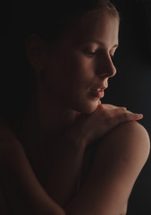 Studio portrait of a girl in dark in the background light