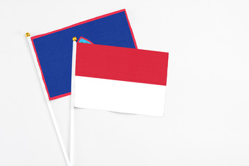 Indonesia and Guam stick flags on white background. High quality fabric, miniature national flag. Peaceful global concept.White floor for copy space.