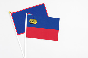 Liechtenstein and Guam stick flags on white background. High quality fabric, miniature national flag. Peaceful global concept.White floor for copy space.