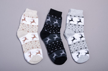 Christmas socks with deer on gray background, top view