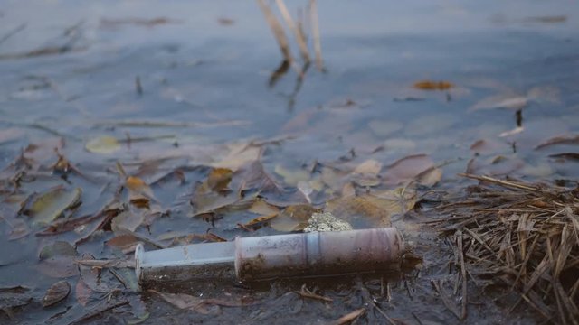 Environmental pollution by medical waste. Syringe after drug injection