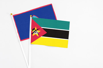 Mozambique and Guam stick flags on white background. High quality fabric, miniature national flag. Peaceful global concept.White floor for copy space.
