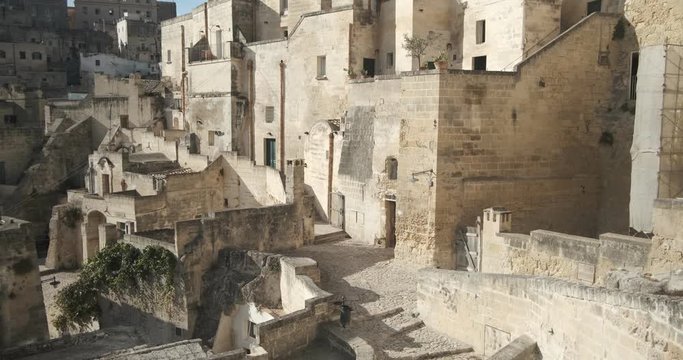 Houses, roads and alleys in the Sassi of Matera. Typical dwellings carved into the rock and with facades of beige tuff blocks.