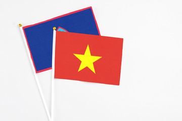 Vietnam and Guam stick flags on white background. High quality fabric, miniature national flag. Peaceful global concept.White floor for copy space.