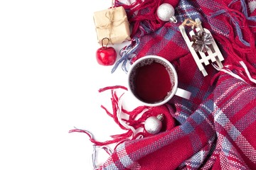 Obraz na płótnie Canvas Hot christmas beverage black tea in mug with new year decorations, Sledge, present, balls, plaid on white. Winter time top view.