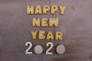 Happy New Year 2020 composed with biscuit letters over wooden board