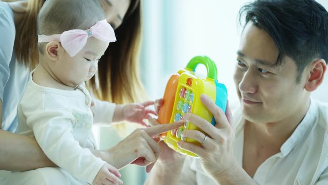 Chinese Asian family enjoying early learning baby telephone
