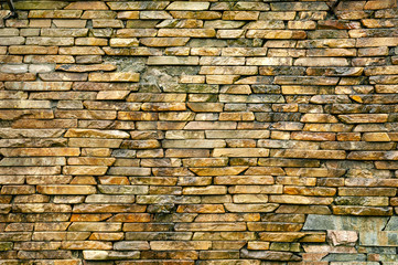 Stone wall. Wall masonry made of hewn, wet wild stone. Stone background.