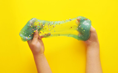 Child hands with slime on background.