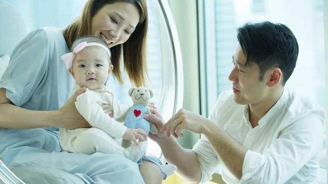 Chinese Asian family content playing with toy bear