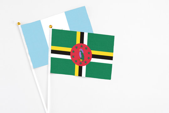 Dominica and Guatemala stick flags on white background. High quality fabric, miniature national flag. Peaceful global concept.White floor for copy space.