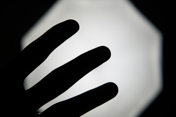 Silhouette hand signal in a studio photo.