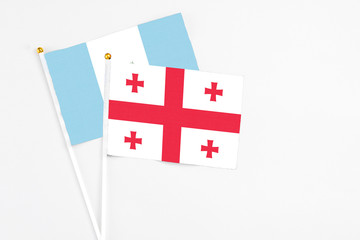 Georgia and Guatemala stick flags on white background. High quality fabric, miniature national flag. Peaceful global concept.White floor for copy space.