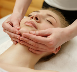 Spa. Massage therapist massaging client's chin