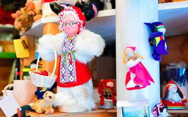 Market stall with traditional souvenirs such as Santa Claus wife at winter Rovaniemi, Lapland, Finland. Street Xmas holiday fair. Advent Decoration and Stalls with Crafts Items on Bazaar