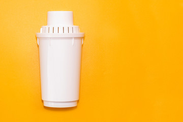 Water filter cartridge on yellow background. Copy space for text. Purification, filtration system concept