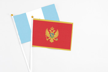 Montenegro and Guatemala stick flags on white background. High quality fabric, miniature national flag. Peaceful global concept.White floor for copy space.