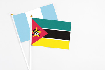 Mozambique and Guatemala stick flags on white background. High quality fabric, miniature national...