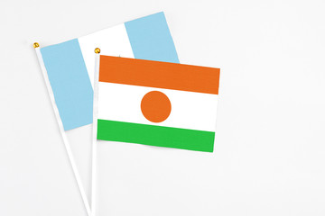 Niger and Guatemala stick flags on white background. High quality fabric, miniature national flag. Peaceful global concept.White floor for copy space.