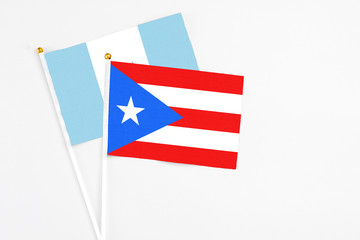 Puerto Rico and Guatemala stick flags on white background. High quality fabric, miniature national flag. Peaceful global concept.White floor for copy space.