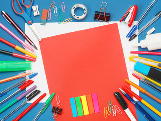 Stationery with blank red paper on blue background. Education concept with copy space for your text. Flat layout, top view.