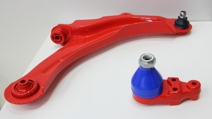 New red car suspension lever and ball joint on white background close up, transmission leverage repair