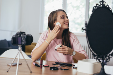 woman makeup vlogger at her home, presenting new line of cosmetic products