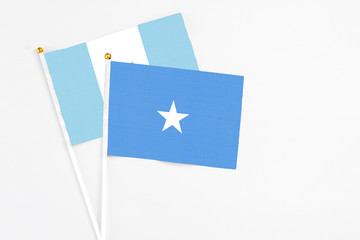 Somalia and Guatemala stick flags on white background. High quality fabric, miniature national flag. Peaceful global concept.White floor for copy space.