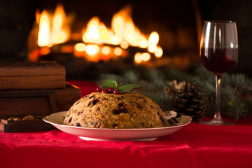 Fototapeta na wymiar english christmas pudding with spoon. english christmas pudding with spoon. Traditional English steamed pudding with dried fruits and nuts for Christmas on the background of the fireplace