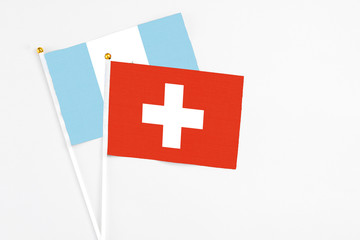 Switzerland and Guatemala stick flags on white background. High quality fabric, miniature national flag. Peaceful global concept.White floor for copy space.