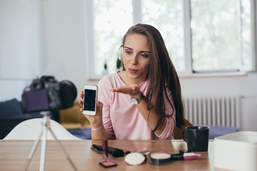 woman makeup vlogger at her home, sending kisses