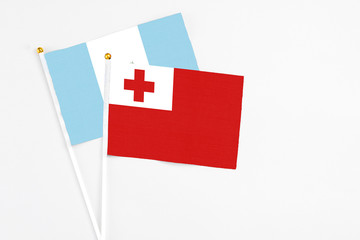 Tonga and Guatemala stick flags on white background. High quality fabric, miniature national flag. Peaceful global concept.White floor for copy space.