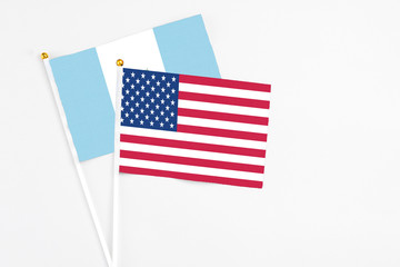 United States and Guatemala stick flags on white background. High quality fabric, miniature national flag. Peaceful global concept.White floor for copy space.
