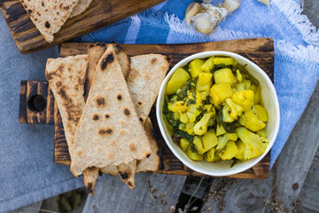 Cooked vegetables. Potato with spinach. Indian sabji with chapati, naan, paratha. 