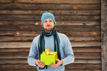 handsome unshaven man holding gift box in hands. holiday present.