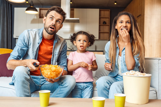Family Watching Tv, Eating Chips And Spending Day Together At Home